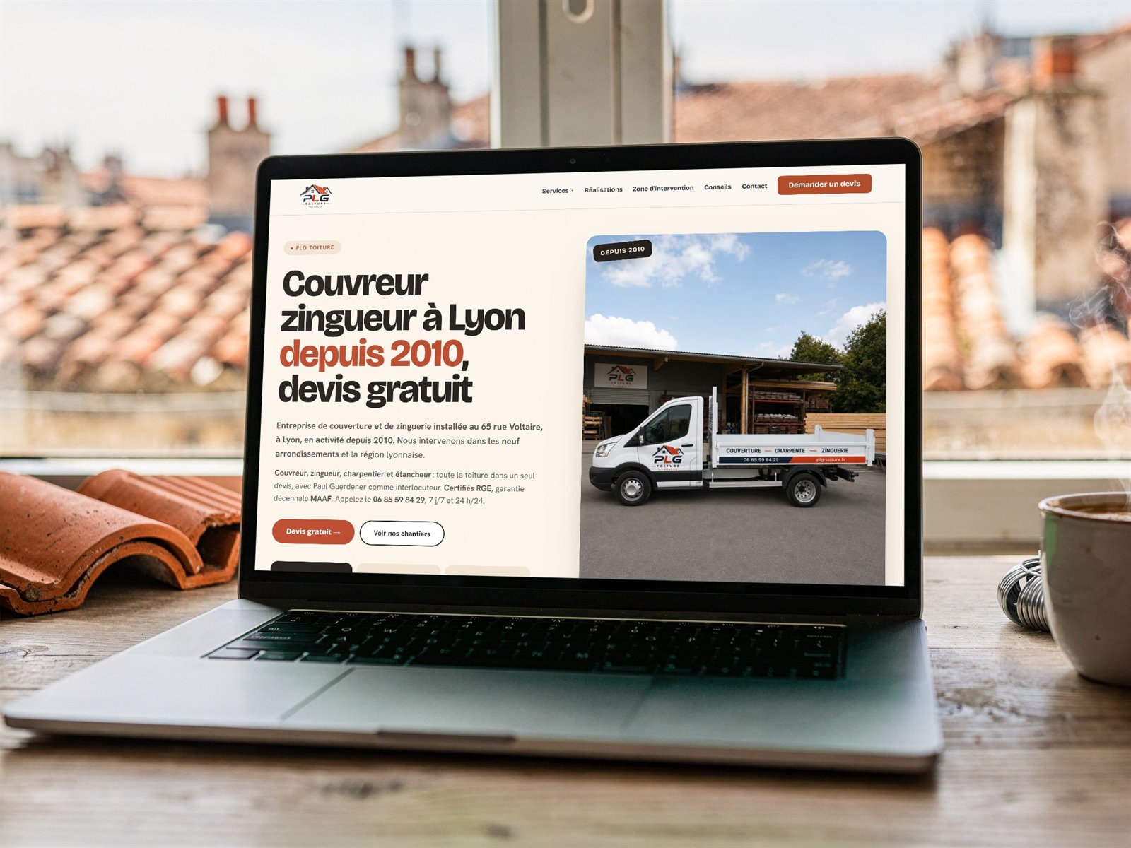 Site internet de PLG Toiture, couvreur zingueur à Lyon, sur un ordinateur devant les toits de la ville